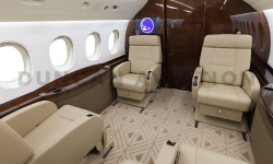 Interior of refurbished Falcon 2000 with tan geometric carpet, tan leather seats, and dark wood