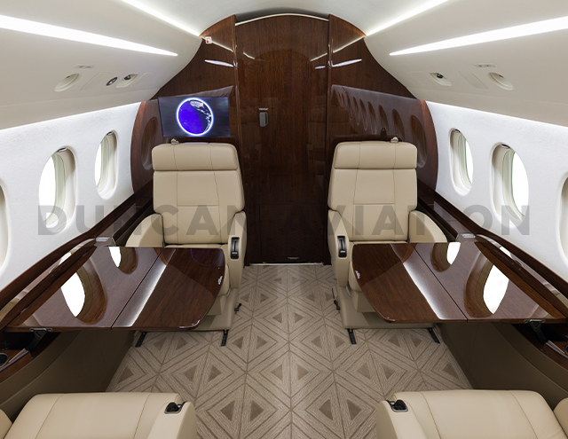 Refurbished Falcon 2000 with tan upholstery and dark wood tables